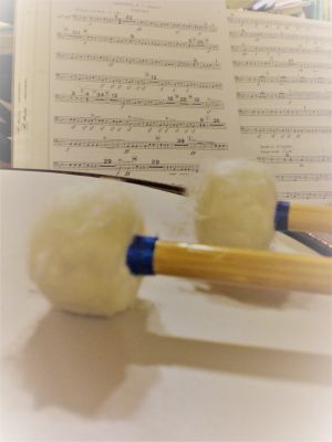 Noten, vor den Noten liegt eine Trommel mit Schlegeln